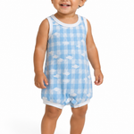 A smiling toddler standing barefoot against a white studio background, wearing a sleeveless light blue and white gingham romper with small white cloud motifs and white trim.