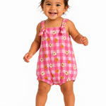 A smiling toddler girl wearing a pink and white gingham bubble romper with a daisy print, standing against a plain white background.